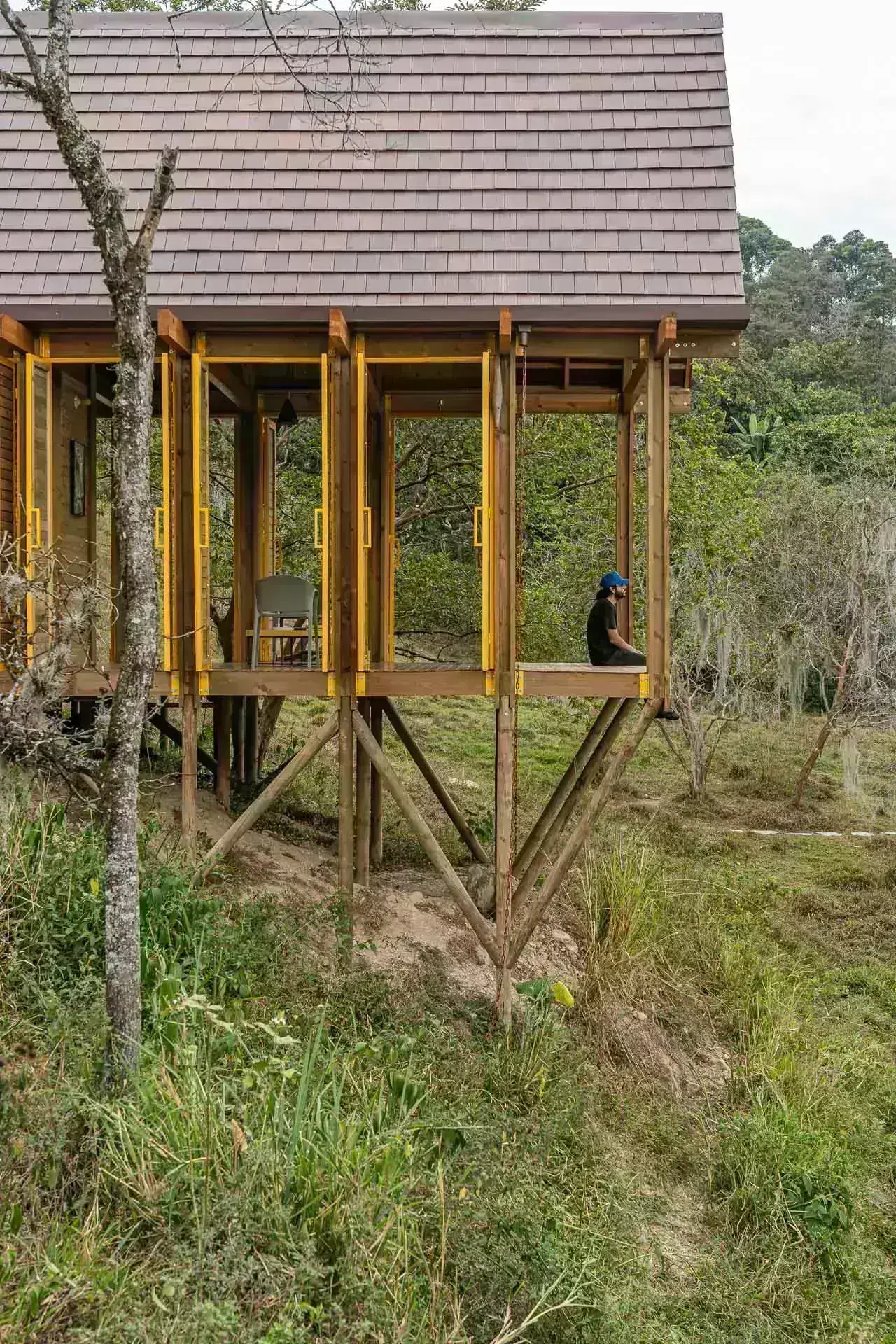 Perspectiva del deck de madera suspendido sobre la ladera con vistas a los cafetales.